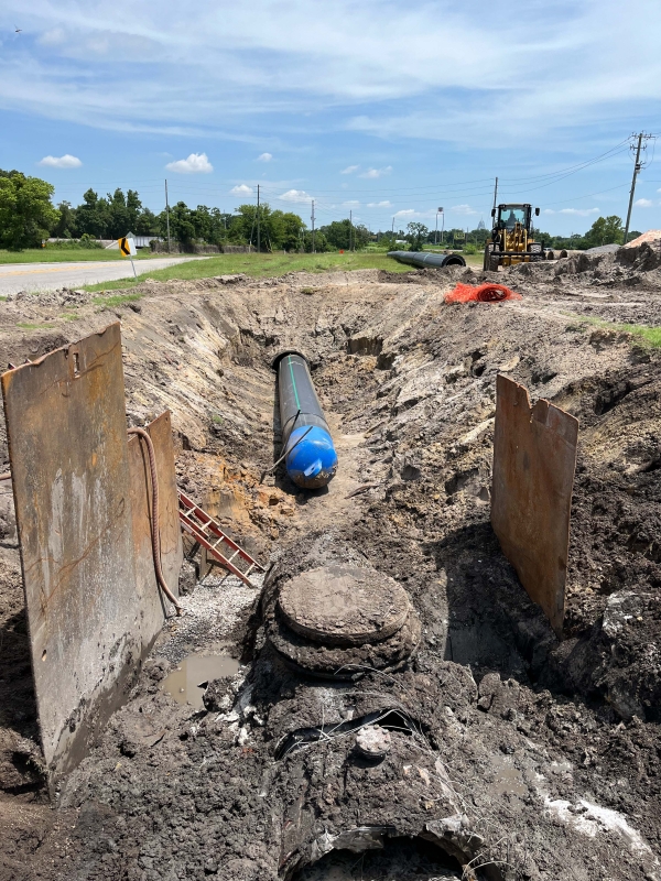 A section of carrier pipe partially inserted into the forcemain.